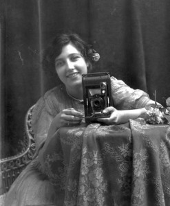 "Young smiling woman, holding a camera" Young smiling woman, holding a camera